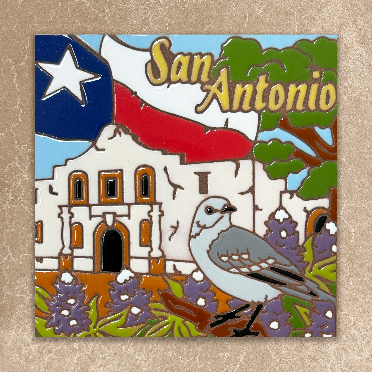 Colorful badge with 'San Antonio' text, Texas flag, building, and bird on a textured beige background