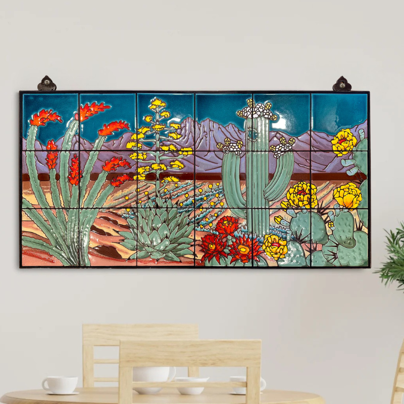 Decorative wall art with desert landscape featuring cacti and flowers on a white wall.