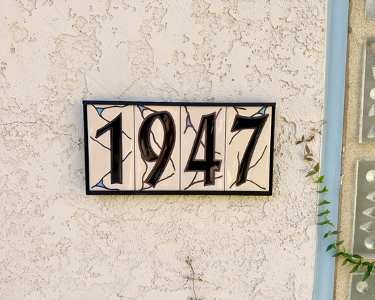 black on beige house number ceramic tile on textured wall