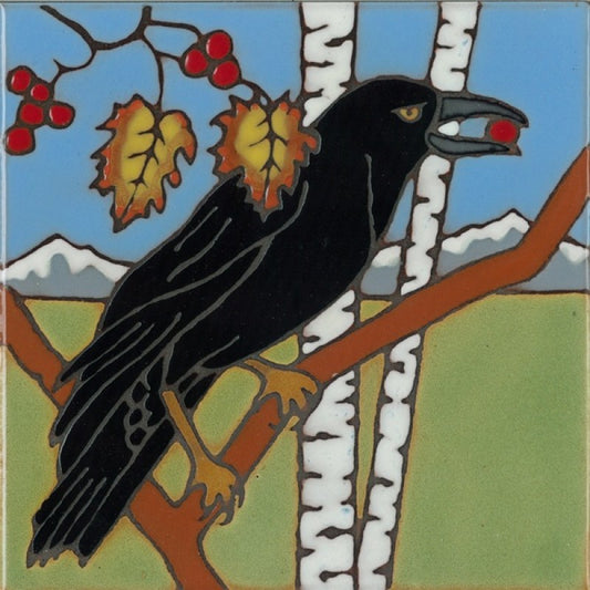 A square ceramic tile featuring a stylized folk-art illustration of a black raven perched on a brown branch, holding a red berry in its beak. The background depicts white birch trees, a blue sky, distant mountains, and green grass with yellow-orange leaves and red berries.