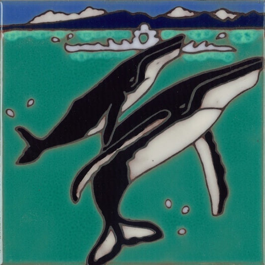 A square ceramic tile featuring a stylized illustration of two whales swimming in turquoise water, with dark blue mountains and white clouds along the top edge.